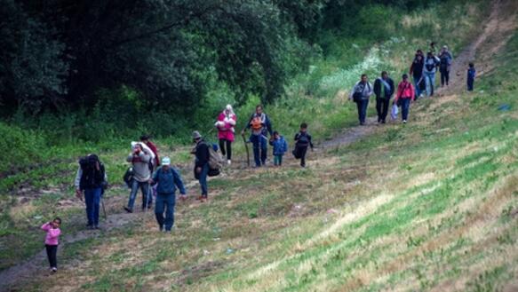Syrische Flüchtlinge überqueren in der Nähe des serbischen Ortes Martonos die Grenze nach Ungarn