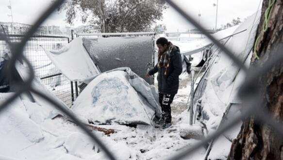 Ein Flüchtling vor einem schneebedeckten Zelt auf der griechischen Insel Lesbos im Januar 2017