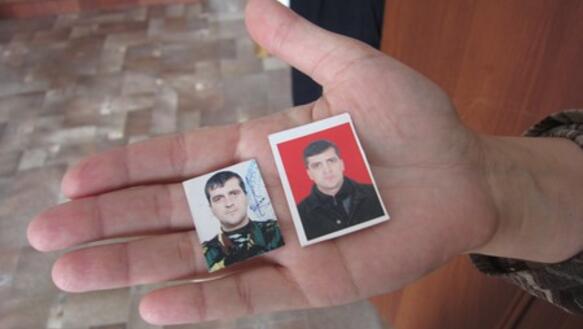 Die Ehefrau von Israil Torshkhoev zeigt Fotos ihres Mannes, der im November 2010 verhaftet und seitdem nicht mehr gesehen wurde