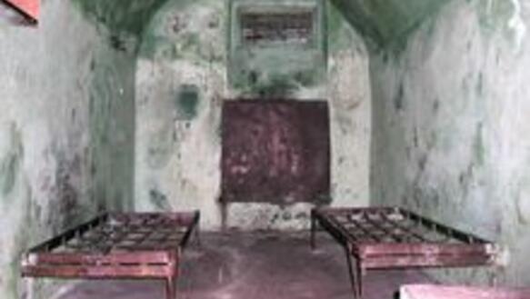 Das Bild zeigt ein Kellergewölbe mit zwei Beetgestellen aus rostigem Stall, ohne Matratze