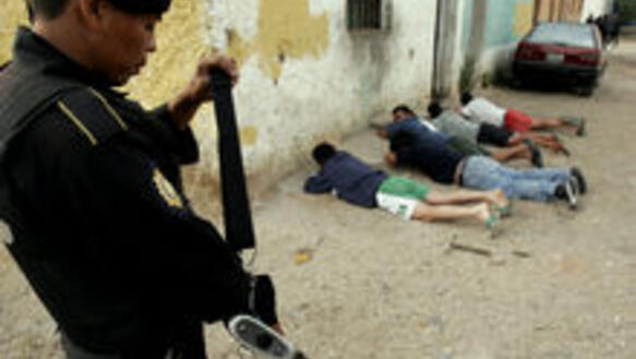 Ein Polizist bewacht ein Gruppe von verhafteten Gangmitgliedern, Guatemala City, März 2006