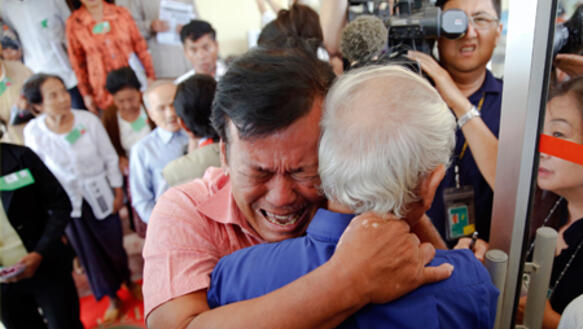 Angehörige von Opfern der Roten Khmer fallen sich nach der Urteilsverkündung gegen zwei ehemalige Anführer in die Arme.