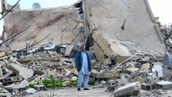 Mustafa Naji al-Morabit vor den Trümmern seines am 4. August 2011 zerstörten Hauses in Zlitan, Libyen, Februar 2012.