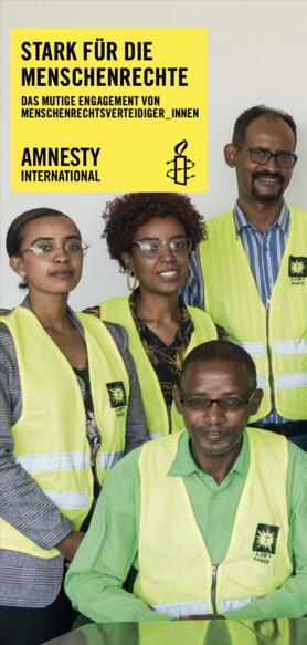 Gruppenbild von vier Menschen, die gelbe Warnwesten mit dem Logo der äthiopischen Menschenrechtsorganisation EHRCO tragen und in die Kamera schauen.