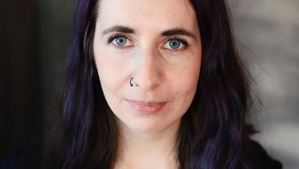 Porträtaufnahme von Nasta Loika, die selbstbewusst und leicht lächelnd in die Kamera blickt.