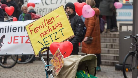 Das Bild zeigt einen Kinderwagen an dem ein Schild befestigt ist: "Familiennachzug jetzt!"