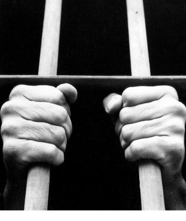 Zwei Hände, die Gitterstäbe umfassen