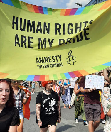Viele Menschen mit bunten Protestplakaten, auf einem steht "Human Rights are my Pride"