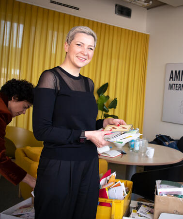 Maria Kalesnikava steht mit Julia Duchrow in einem Besprechungsraum von Amnesty. Beide lächeln in die Kamera