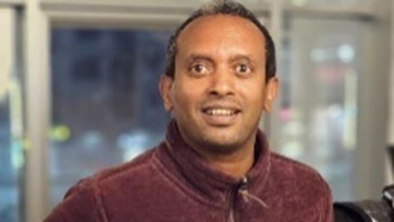 Porträtfoto von Million Beyene, der in die Kamera lächelt.